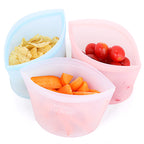 Trois contenants en silicone remplis de croustilles, de tomates cerises et de carottes