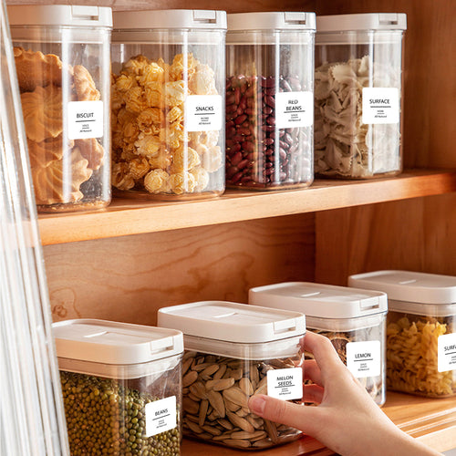 Contenants de garde-manger étiquetés, rangés sur des tablettes en bois